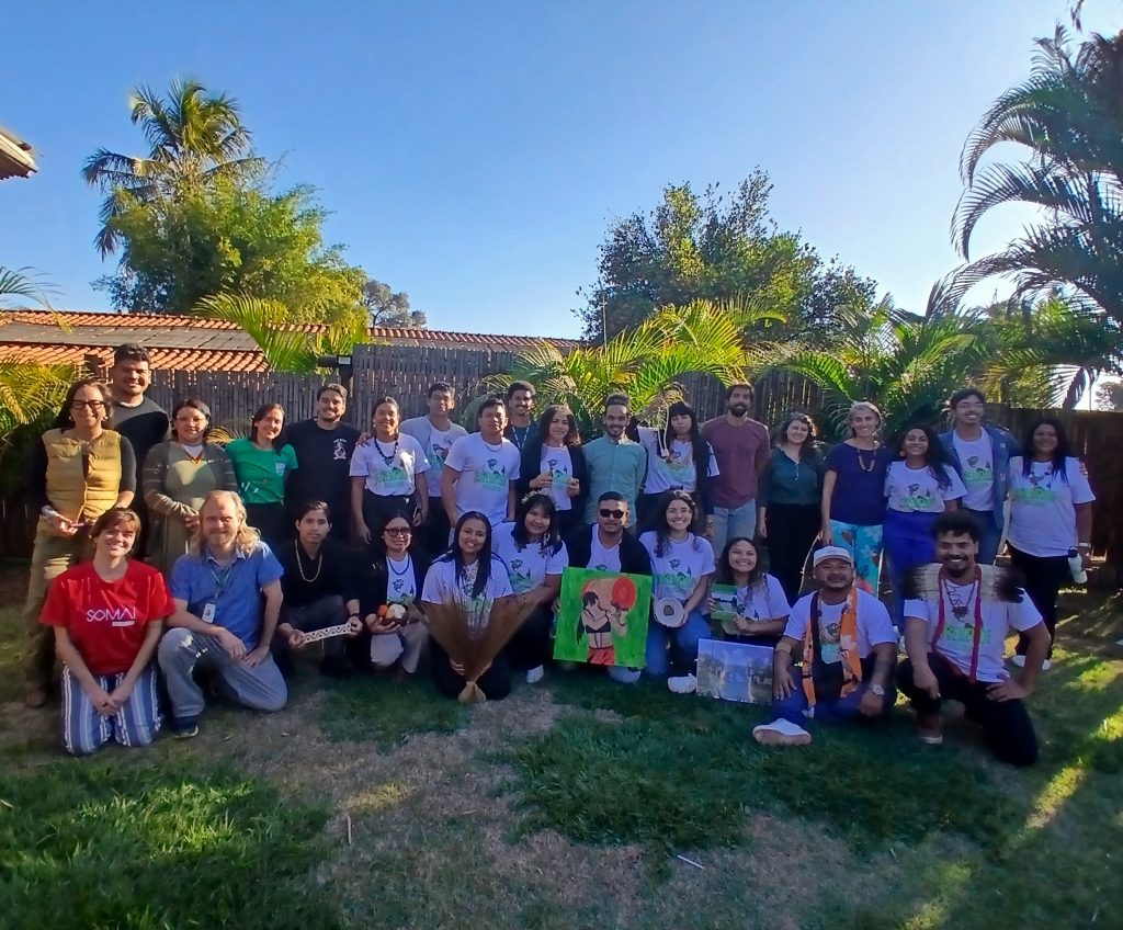 Foto mostrando jovens unidos em pé e sorrindo, presente no texto: Jovens de 18 comunidades apresentam planos de adaptação climática